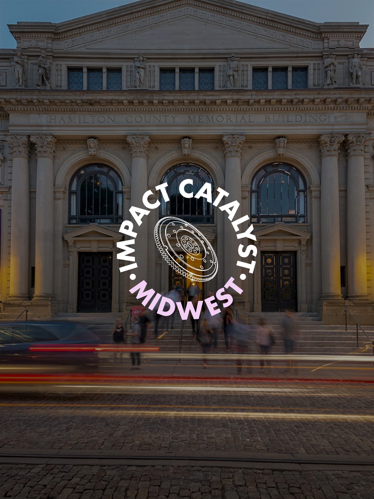 Impact Catalyst Midwest badge with a line-drawn flywheel, over a dusk photo of the Hamilton County Memorial Building
