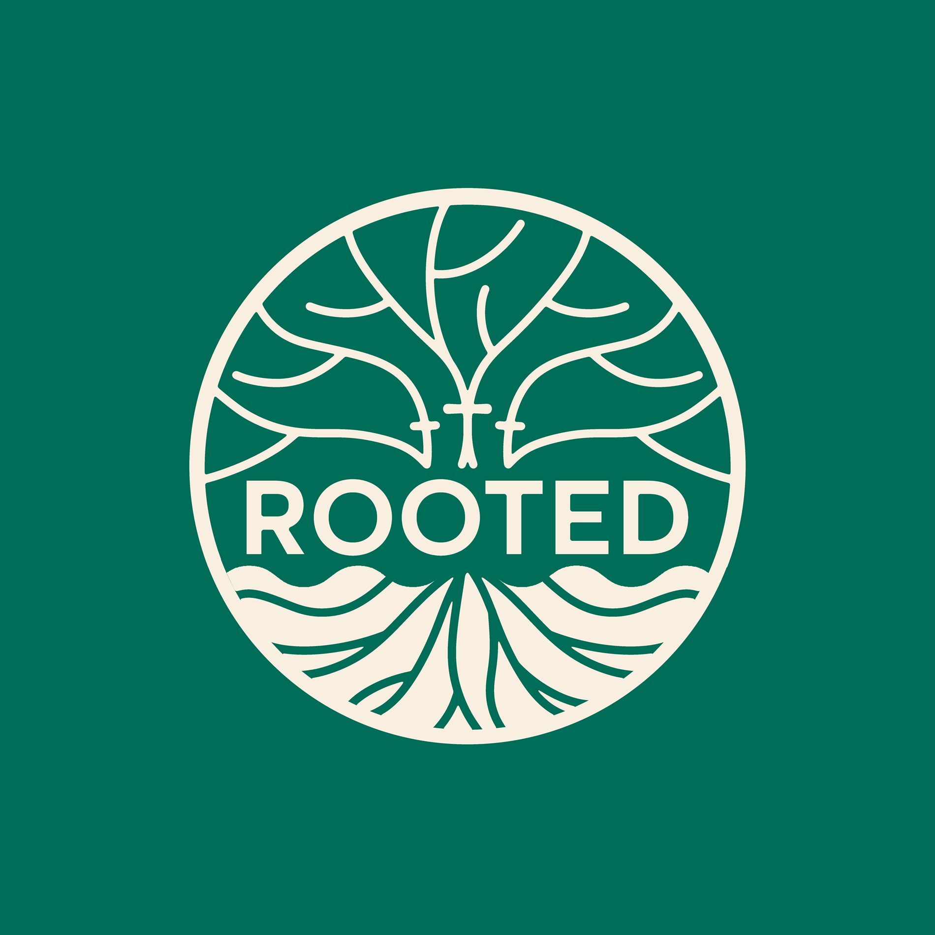The Rooted badge, a cream tree with branches above and roots below inside a circle on a deep green field, with a small cross in the trunk