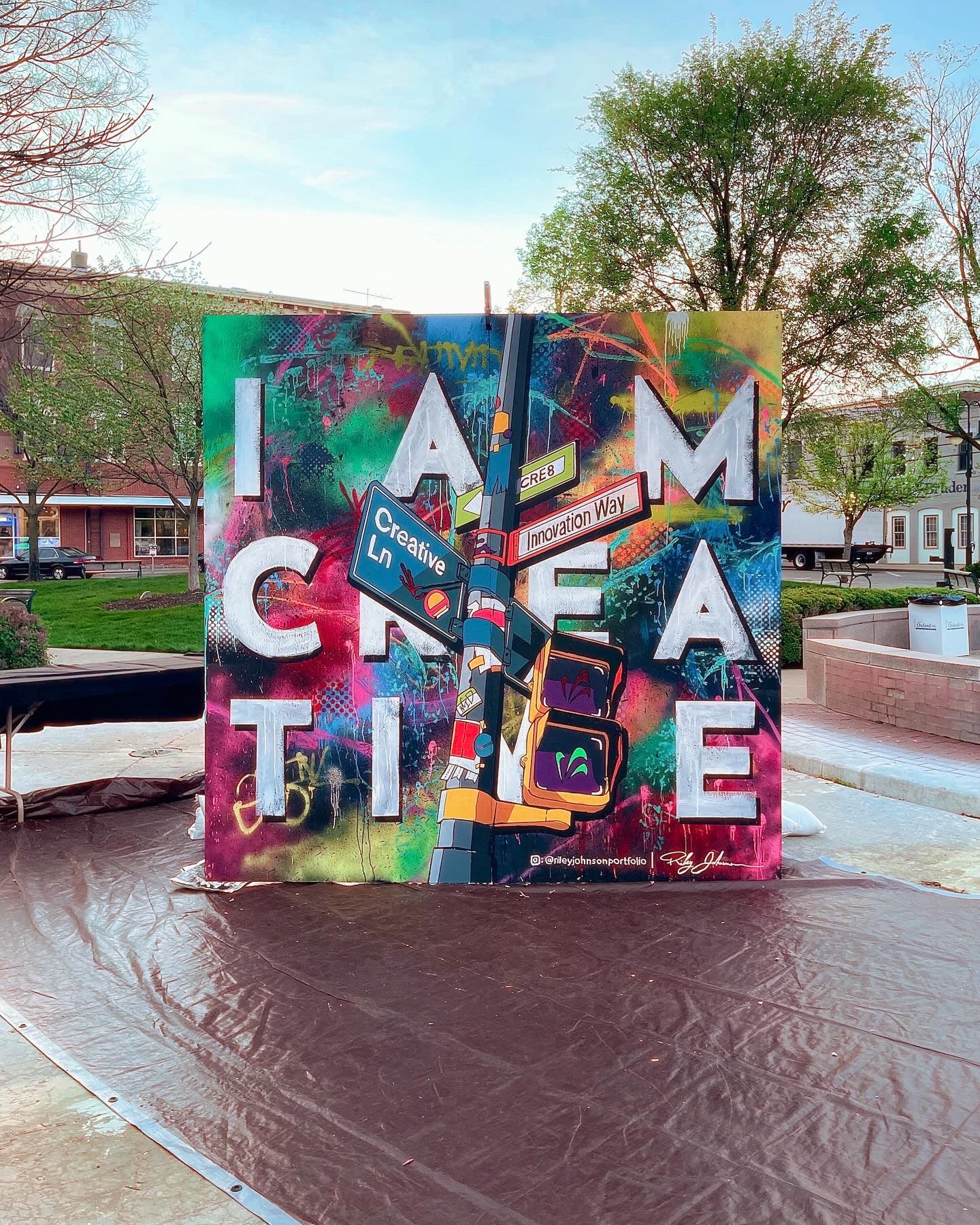 I Am Creative mural by Studio Roo, a vibrant graffiti-style piece reading I AM CREATIVE with painted street signs